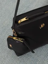 Cartera tipo tote confeccionada en cuero vacuno color negro, con cierre superior y forro interior de jacquard. Incluye bolsillo interno, correa larga regulable y desmontable, correa corta para usar al hombro y bolsillo desmontable con cierre.