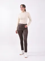 Pantalón chupín de cuero sintético color negro, tiro alto y corte ajustado.