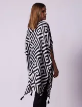 Kimono tejido con estampado geométrico en blanco y negro, con terminación de ruedo con borlas.