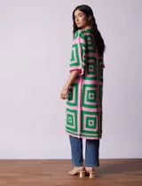 Cardigan largo tejido al crochet con diseño geométrico en verde y rosa. Tiene mangas 3/4 y corte holgado.
