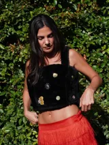 Top corto de corderito color crudo, con breteles y cierre con broches en la espalda. Decorado con pins y tachas variadas.