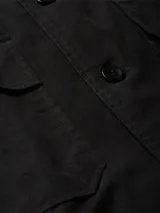 Sobrecamisa negra de sarga de algodón y nailon, corte boxy, cuello italiano, bolsillos con solapa en el pecho, billetera con botones, bajo recto, botones de gran tamaño e insignia con el logo de Calvin Klein en la manga.
