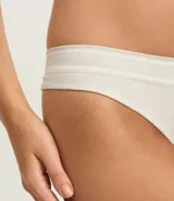 Bombacha de bikini color beige claro, confeccionada en poliamida con tecnología seamless y textura. Presenta un corte bikini clásico y un borde liso.