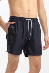 Short de baño azul marino con bordado de enredadera en la pierna izquierda, cintura elástica con cordón ajustable, bolsillos laterales y bolsillo trasero con cierre.