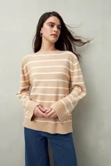 Sweater de punto a rayas horizontales color beige y blanco, con cuello bote y corte holgado.