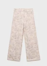 Pantalón de jean de corte wide leg con estampado floral en tonos pastel. Tiene tiro alto, cinco bolsillos, trabillas y cierre frontal con cremallera y botón.