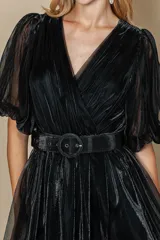 Vestido largo negro de tul con escote en V, mangas cortas abullonadas y cinturón con hebilla redonda.
