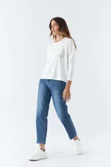 Remera blanca de algodón con mangas largas, cuello redondo y estampado frontal con la palabra 'Faith' en letras de diferentes colores.