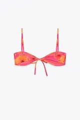 Top de bikini con estampado de flores, escote corazón y tirantes finos ajustables. Cierre trasero con gancho metálico.
