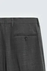 Pantalón de vestir gris oscuro, corte slim fit, confeccionado en tejido con 17% de lana. Cuenta con bolsillos frontales y traseros de vivo con botón. Cierre frontal con cremallera y botón.