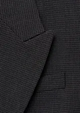 Chaqueta gris con estampado de micro pata de gallo, cuello con solapa, cierre de botón frontal, dos bolsillos delanteros con ribete y solapa, manga larga abotonada y forro interior.