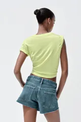 Camiseta gris con efecto lavado, cuello redondo y mangas cortas. Estampado frontal con la frase "I LEFT MY WORRIES IN TULUM" en amarillo.