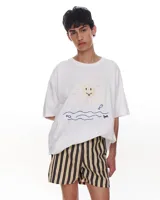 Remera blanca de corte holgado con estampado de un sol, olas y peces.