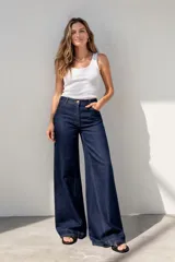 Pantalón de jean de tiro alto, color azul oscuro, de corte ancho y pierna muy ancha (palazzo o wide leg).