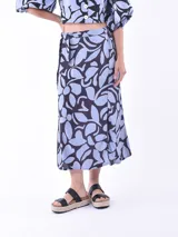 Falda midi de corte recto con estampado de hojas en tonos celeste y negro. Tiene lazo ajustable en la cintura.