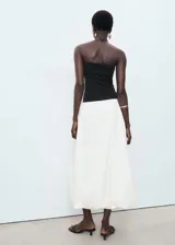 Vestido midi de algodón, con corpiño negro tipo palabra de honor ajustado y falda blanca con volumen estilo globo.