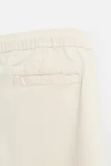 Bermuda color beige de denim de algodón, corte relaxed fit, con cintura elástica ajustable con cordón, bolsillos frontales y traseros.