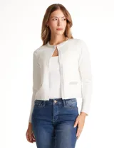 Chaqueta tejida blanca de la marca Rio & Rian, con cuello a la base bordado con perlas y canutillos. Cuenta con broche de enganche interno, bolsillos simulados en la delantera con aplique de brillos, y vivo delantero y puños en tejido lurex.