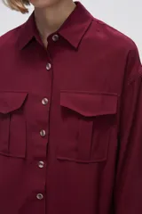 Camisa color crudo de viscosa, corte holgado, con cuello camisero, cierre frontal con botones, manga larga y dos bolsillos con solapa en el pecho.
