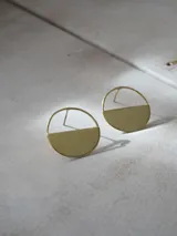 Par de aros dorados con forma circular, divididos horizontalmente: la mitad superior es un aro fino y la mitad inferior es un semicírculo sólido.