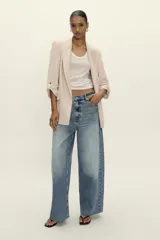 Blazer blanco con cuello solapa y hombreras. Manga por debajo del codo acabada en vuelta con trabilla y botón dorado. Bolsillos delanteros con solapa.