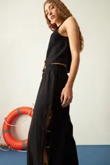 Pantalón negro de algodón y lino, corte recto, con cintura elástica y mostacillas en los laterales.