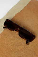 Lentes de sol Urban Haus modelo Égida, con montura rectangular de carey y lentes marrones.