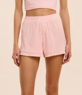 Short de pijama rosado con estampado de corazones, cintura elástica, botones decorativos y volados en el ruedo.