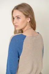 Sweater de lana azul con mangas ranglan color beige.