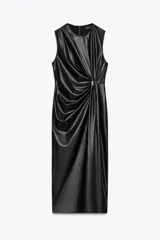 Vestido midi negro de cuero sintético, sin mangas, con cuello redondo, frunces y pieza metálica dorada en el delantero, abertura en el bajo y cierre trasero con cremallera oculta.