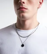 Set de dos collares para hombre, con cadena de eslabones plateada y cadena fina con colgante circular negro.