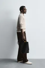 Sweater tipo polo color beige, de punto con mezcla de algodón y lana, corte regular fit, cuello solapa con abertura en V y mangas largas con terminaciones en rib.