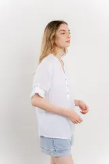 Camisa celeste de lino con cuello mao, escote en V abotonado, bolsillo en el pecho y mangas 3/4 con trabilla.