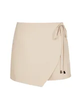 Short pollera color beige claro, con corte cruzado y lazo lateral.