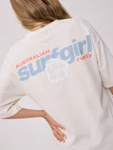Remera color crudo con estampado frontal y trasero con la leyenda "Surf Girl Rusty". Corte oversize y confeccionada en algodón.