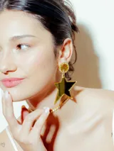 Aros colgantes dorados con forma de estrella y base circular con strass.