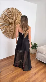 Vestido largo negro de tejido de punto con escote recto y breteles finos. La falda es de encaje transparente. Incluye una bufanda fina al tono.
