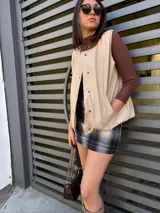 Chaleco color beige con botones y cuello en V.