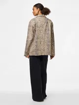 Blazer con estampado animal print en tonos beige y gris, de corte clásico con solapas y bolsillos delanteros.