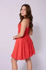 Vestido corto celeste con breteles finos, escote fruncido con lazo y falda con corte globo.