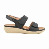 Sandalias bajas negras con plataforma color beige, tiras anchas con perforaciones y ajuste con hebilla.