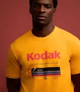 Remera amarilla de algodón con cuello redondo y mangas cortas. Estampado frontal con el logo de Kodak y un rollo de película.