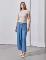 Pantalón capri de lyocell celeste, corte wide leg, con pretina elástica ajustable con lazo y bolsillos delanteros.