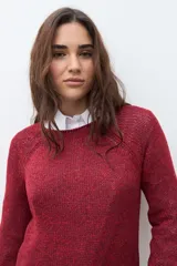 Sweater de tejido de punto color verde oliva jaspeado, con escote redondo y mangas largas con ligero acampanado en los puños.