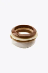Pack de cuatro pulseras de resina de diferentes tamaños en tonos marrón, beige y blanco.