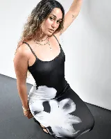 Vestido largo negro con estampado de flores blancas, de breteles finos y corte ajustado.