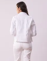 Campera de jean blanca, marca Baccini, con cuello solapa, bolsillos delanteros, abertura central con botones metálicos y terminación desflecada en el ruedo.
