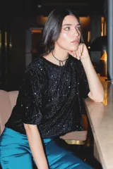 Remerón de tela velvet con lentejuelas, de corte a la cadera y manga por encima del codo.