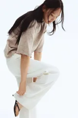 Remera de punto color beige melange, con cuello redondo, mangas cortas amplias y puños y bajo acanalados.