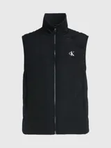 Chaleco negro acolchado de nailon reciclado con cuello alto, cierre de cremallera, bolsillos con cremallera en la cintura y logo de Calvin Klein en el pecho y la nuca.